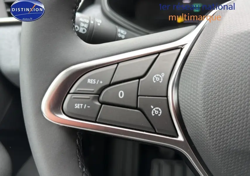 Gros plan sur les commandes de régulateur de vitesse au volant de la Renault Clio V Bleu iron, intérieur moderne.