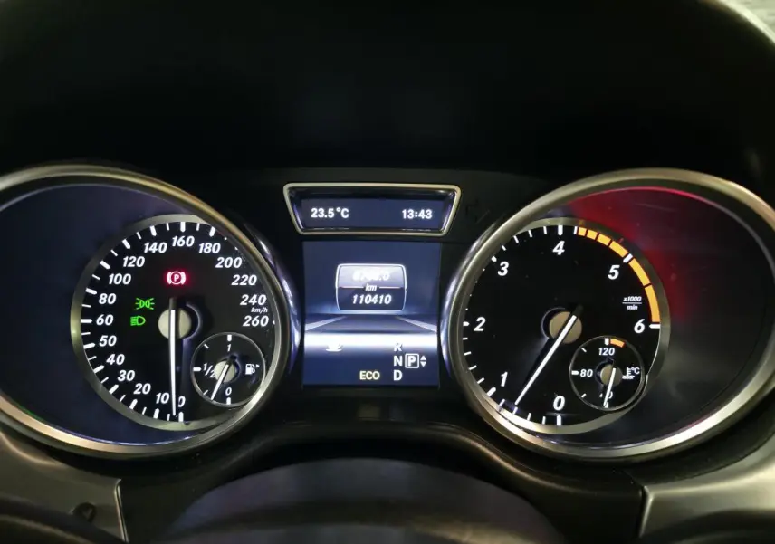 Vue rapprochée du combiné d'instruments noir de la Mercedes Classe M 2014 avec affichage digital et compte-tours.