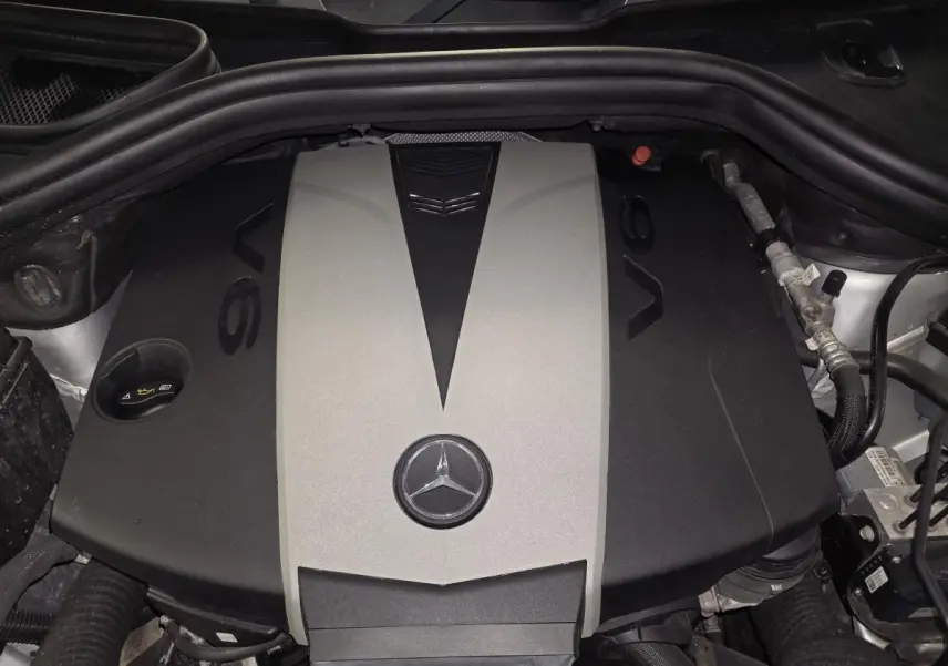 Vue rapprochée du moteur V6 gris et noir du Mercedes Classe M ML 350 BlueTEC 2014 avec logo étoile central visible.