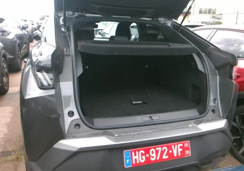 Vue arrière du Peugeot 3008 gris foncé 2025 avec coffre ouvert, soulignant son espace de chargement spacieux.