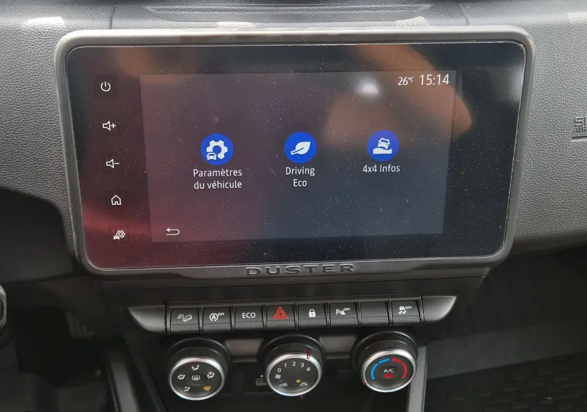 Écran tactile central du tableau de bord du Dacia Duster 2023 avec affichage des paramètres véhicule et commandes climatisation.