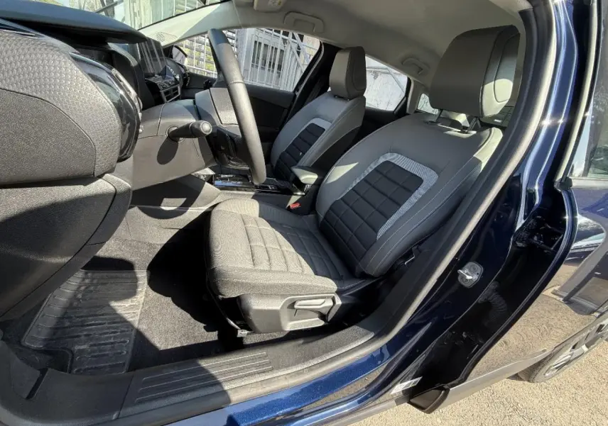 Vue intérieure côté conducteur de la Citroën C4 2025 en new dark blue, montrant les sièges gris et le tableau de bord moderne.