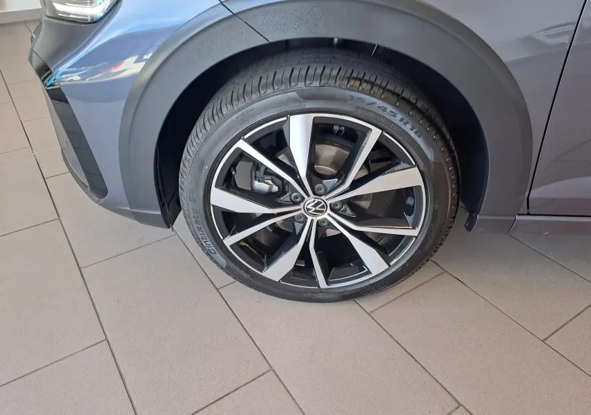 Gros plan sur la roue avant gauche du Volkswagen Taigo gris cendre, jante alliage 18 pouces Misano bicolore.