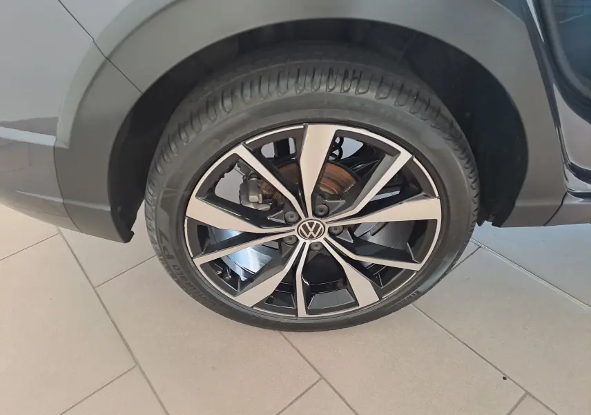 Gros plan sur la jante alliage 18'' Misano bicolore noir et argent du Volkswagen Taigo gris cendre côté arrière droit.