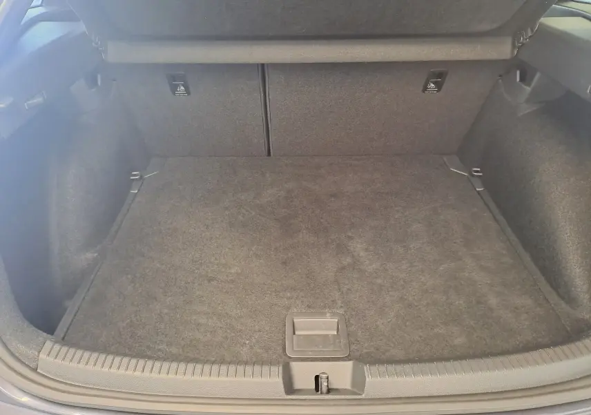 Coffre ouvert vu de face du Volkswagen Taigo gris cendre, montrant un espace de chargement propre et spacieux.