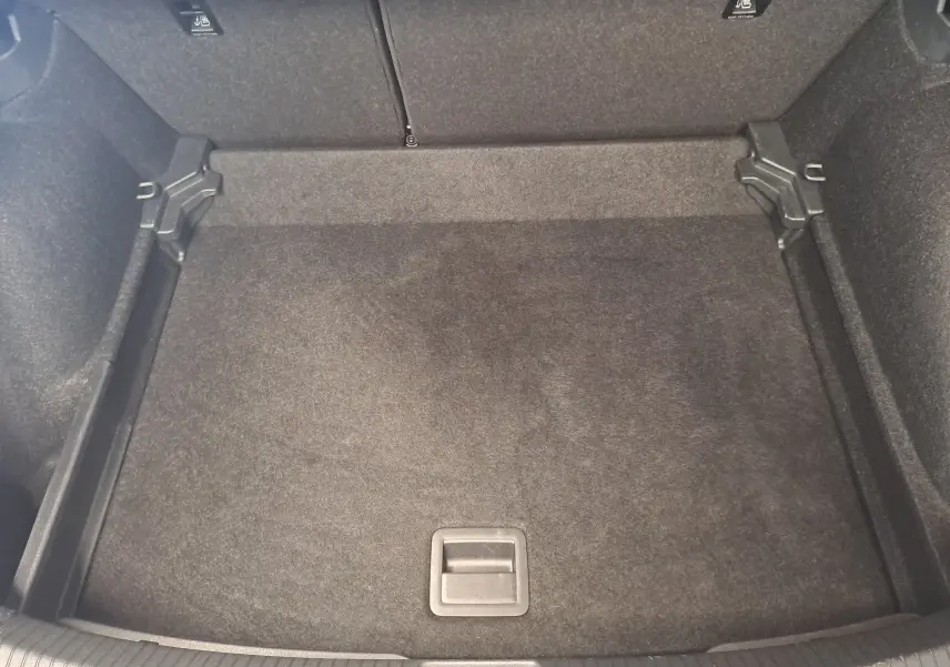 Coffre vide vu de dessus du Volkswagen Taigo gris cendre, finition R-Line Edition 2025, avec tapis de sol noir.