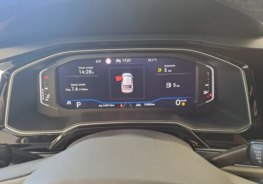 Affichage numérique du tableau de bord du Volkswagen Taigo 1.0 TSI R-Line, montrant l'autonomie et la vitesse à 0 km/h.
