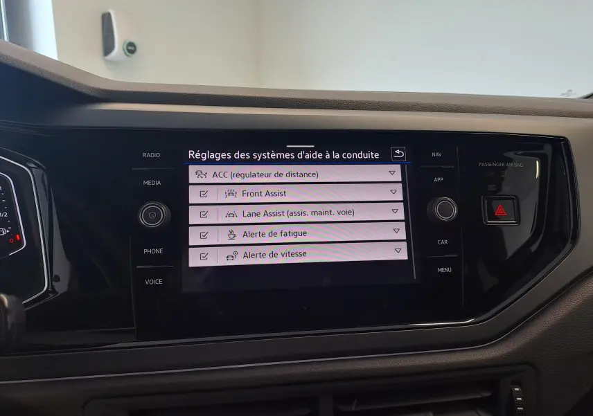 Écran central du Volkswagen Taigo 2025 affichant les réglages des aides à la conduite, intérieur noir.