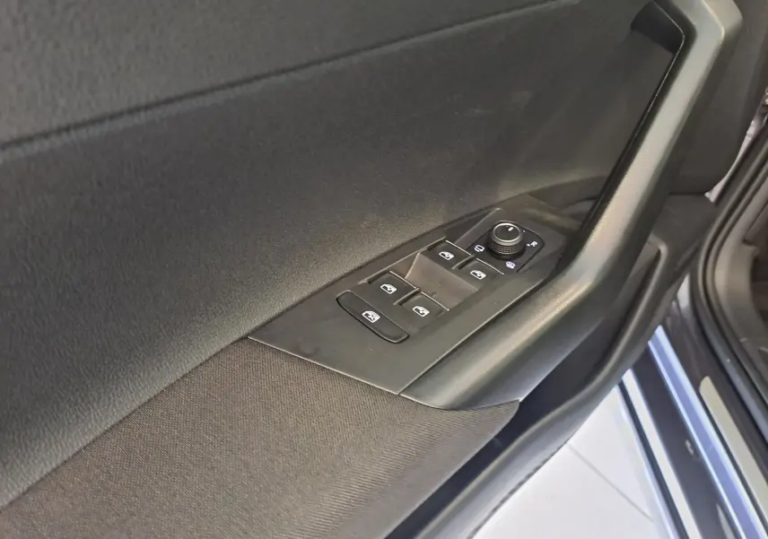 Détail de la commande des vitres et rétroviseurs sur la porte côté conducteur d’un Volkswagen Taigo gris cendre.