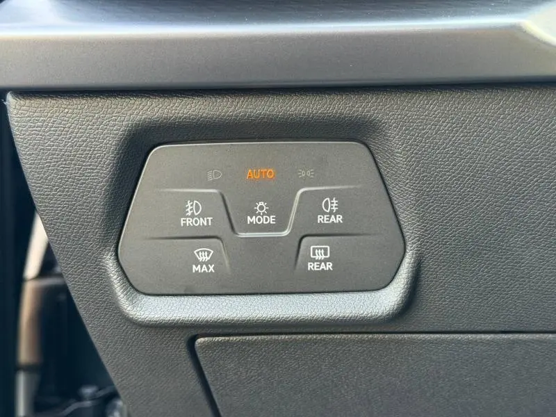 Gros plan sur les commandes d’éclairage et de dégivrage du tableau de bord du SEAT LEON 1.5 eTSI Hybrid gris magnétique.