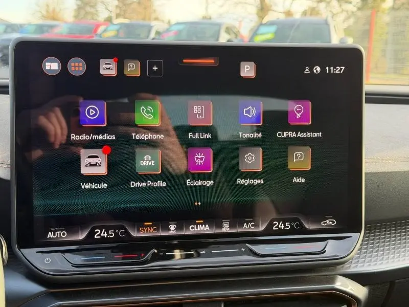Écran tactile central du tableau de bord du SEAT LEON 2025 affichant les options multimédia et climatisation.