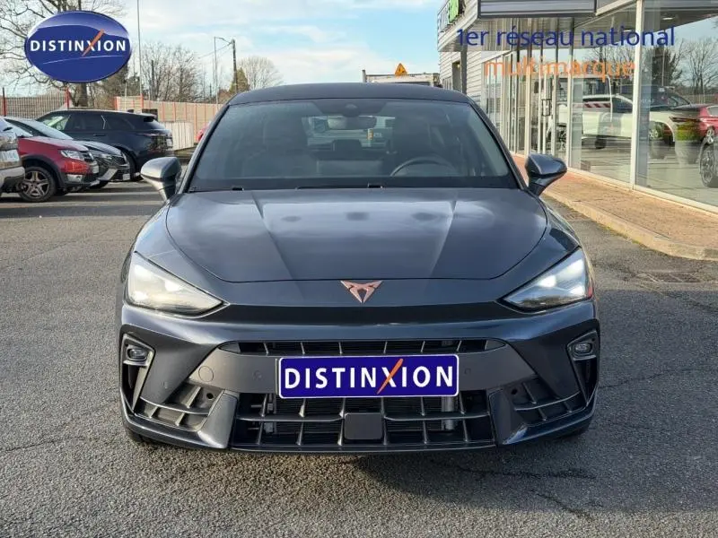Vue frontale d'une SEAT Leon 1.5 eTSI Hybrid gris magnétique métallisé avec logo distinctif Cupra sur le capot.