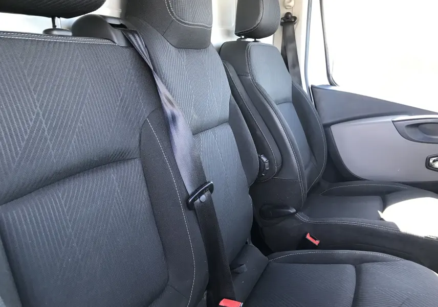 Intérieur du Renault Trafic Fourgon 2017, vue côté droit sur les sièges avant noirs avec ceinture de sécurité visible.