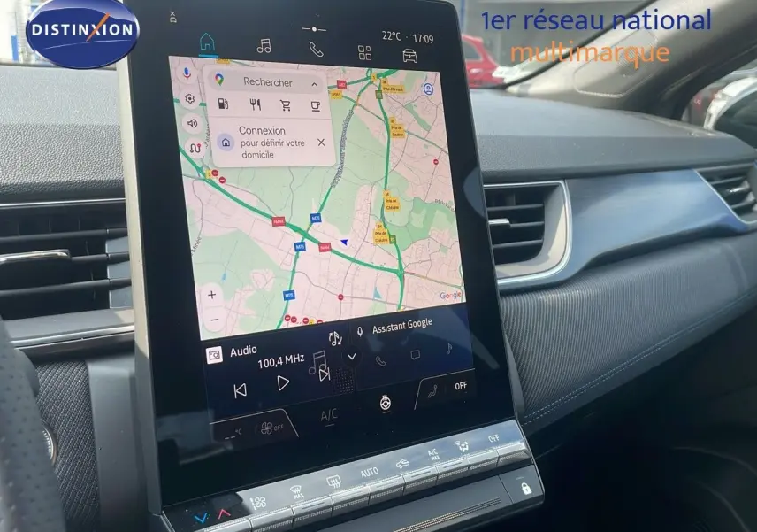 Vue intérieure centrée sur l'écran tactile du tableau de bord du Renault Captur gris cassiopée 2025 avec toit noir.