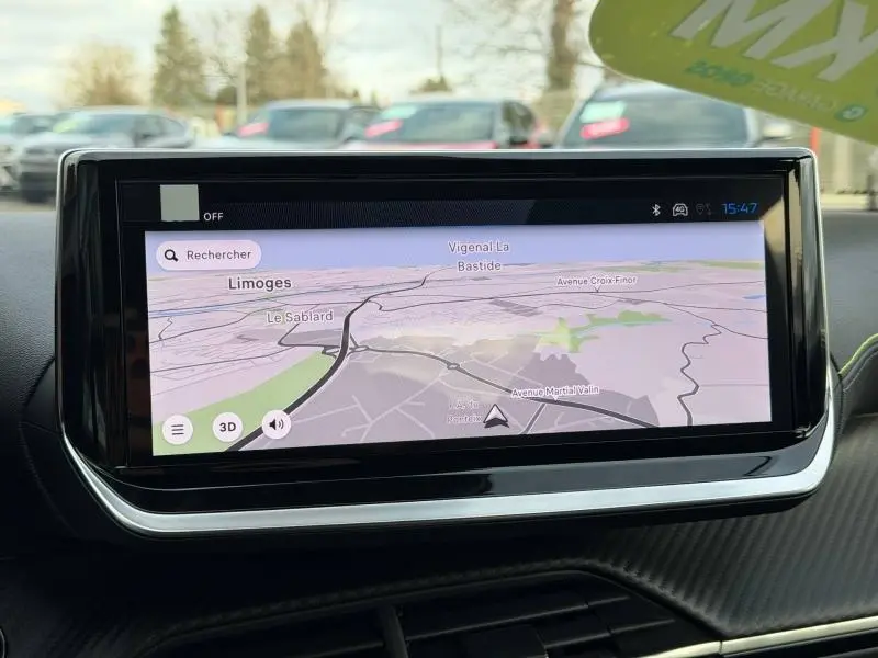 Écran tactile central du tableau de bord du Peugeot 2008 bleu, affichant la navigation GPS en plein jour.