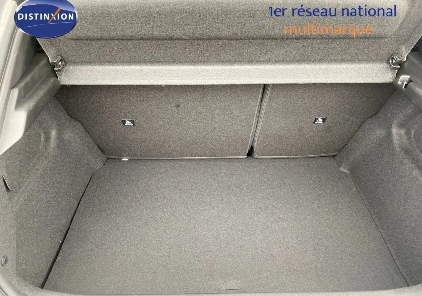 Coffre ouvert d'une Peugeot 208 Hybrid 145ch gris selenium metal, montrant un espace de rangement propre et spacieux.