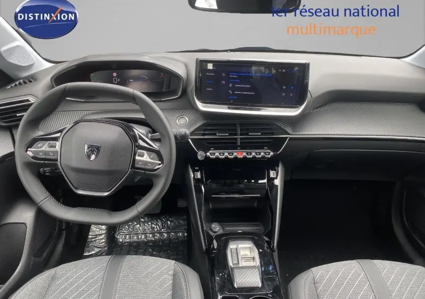 Vue intérieure avant de la Peugeot 208 Hybrid 145ch Allure 2026, tableau de bord noir avec écran tactile et volant compact.