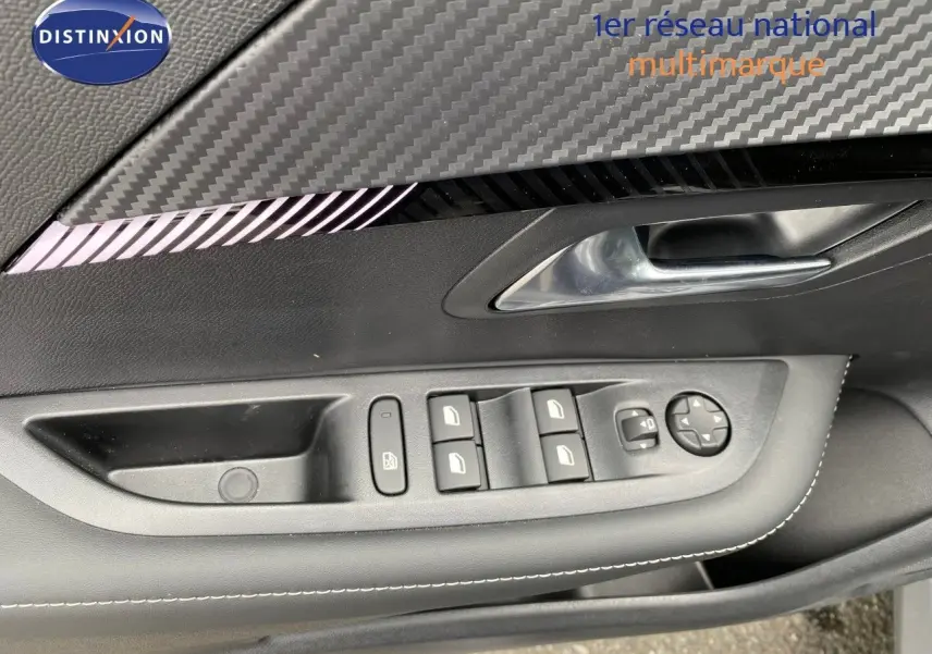 Détail de la porte côté conducteur de la Peugeot 208 Hybrid 145ch Allure 2026, avec commandes des vitres et insert décor carbone.