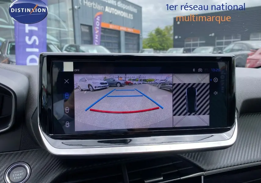 Écran central montrant la caméra de recul avec vue arrière et top-down d’un Peugeot 208 gris Selenium.