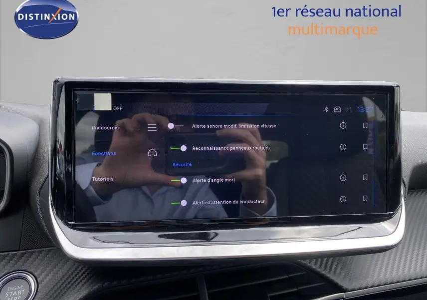 Écran tactile du tableau de bord de la Peugeot 208 gris sélénium, affichant les options d’alerte et sécurité.