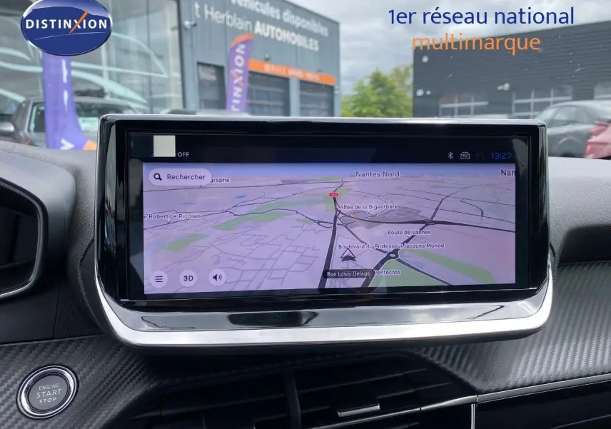 Vue rapprochée de l’écran tactile central du tableau de bord du Peugeot 208 gris, affichant la navigation GPS.