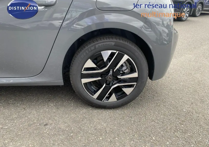 Gros plan sur la roue arrière droite d'une Peugeot 208 gris selenium métal avec jante alliage noire et argent.