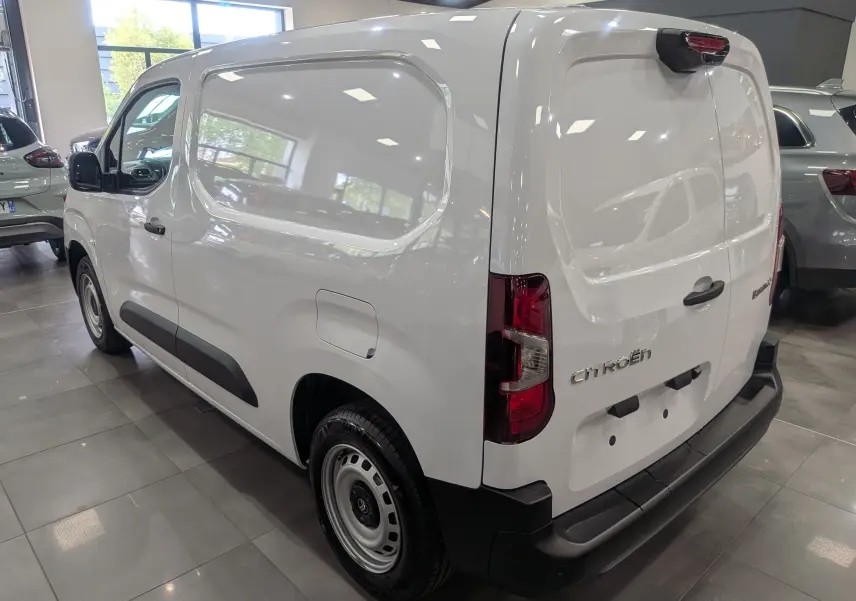 Vue 3/4 arrière droite d'un Citroën Berlingo blanc 2025, fourgon utilitaire avec portes arrière pleines et protections noires.