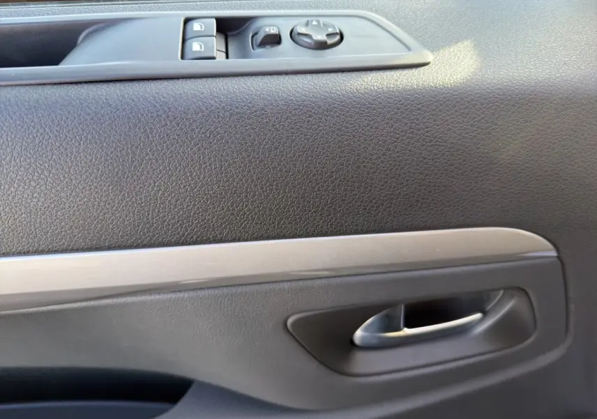 Gros plan sur la porte intérieure côté conducteur du Peugeot Expert Fourgon gris foncé, avec commandes électriques et poignée argentée.