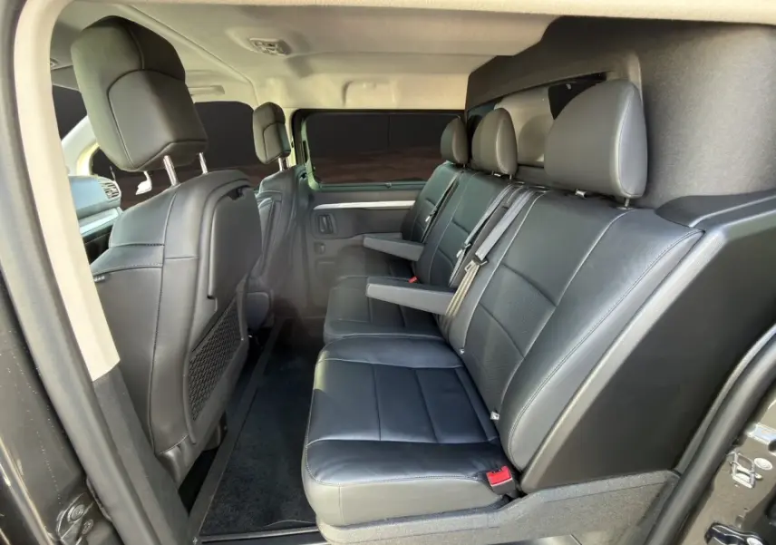 Vue intérieure côté droit du Peugeot Expert Fourgon XL 2026, sièges arrière en cuir noir avec accoudoirs.