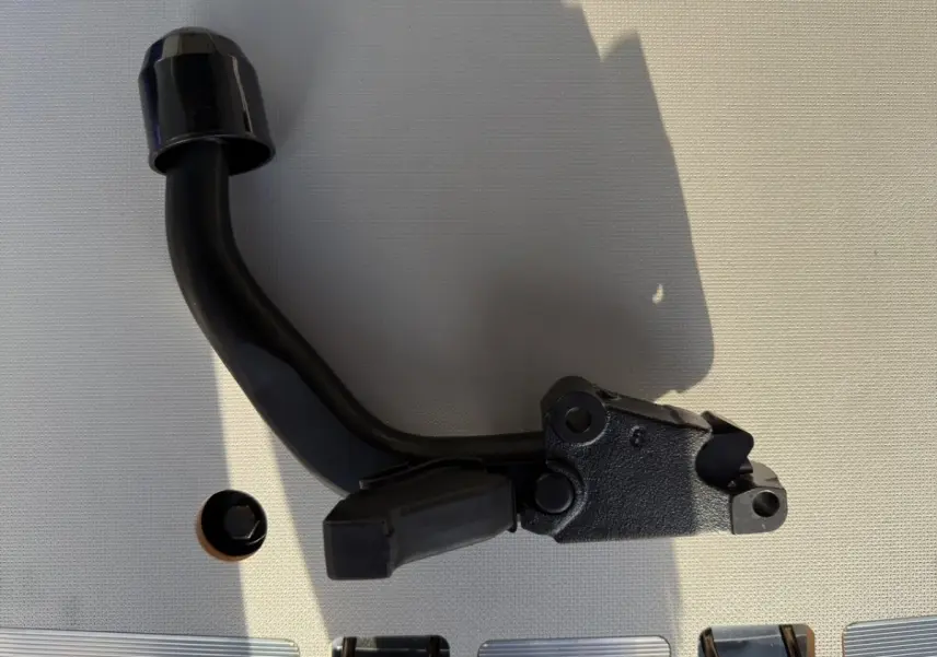 Pièce mécanique noire vue de profil sur fond clair, sans véhicule visible ni éléments distinctifs liés au Peugeot Expert Fourgon.