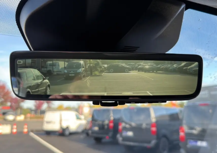 Vue du rétroviseur intérieur numérique du Peugeot Expert Fourgon gris foncé, affichant le parking arrière avec plusieurs véhicules.