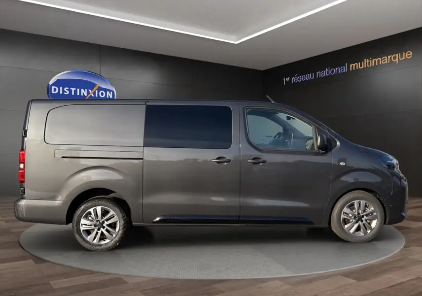 Profil droit du Peugeot Expert Fourgon gris foncé 2026 avec vitres teintées et jantes alliage visibles.