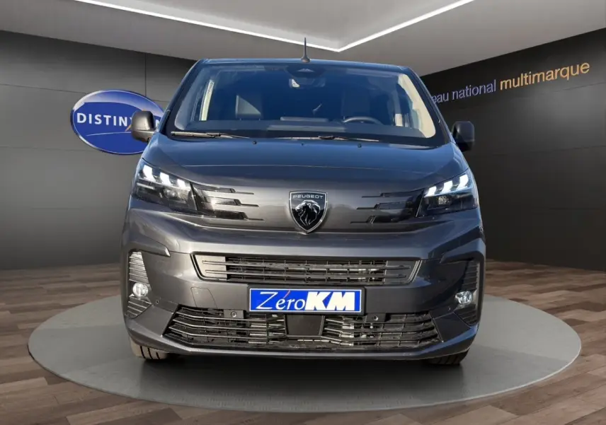Vue de face du Peugeot Expert Fourgon gris foncé avec phares LED et logo lion central bien visible.