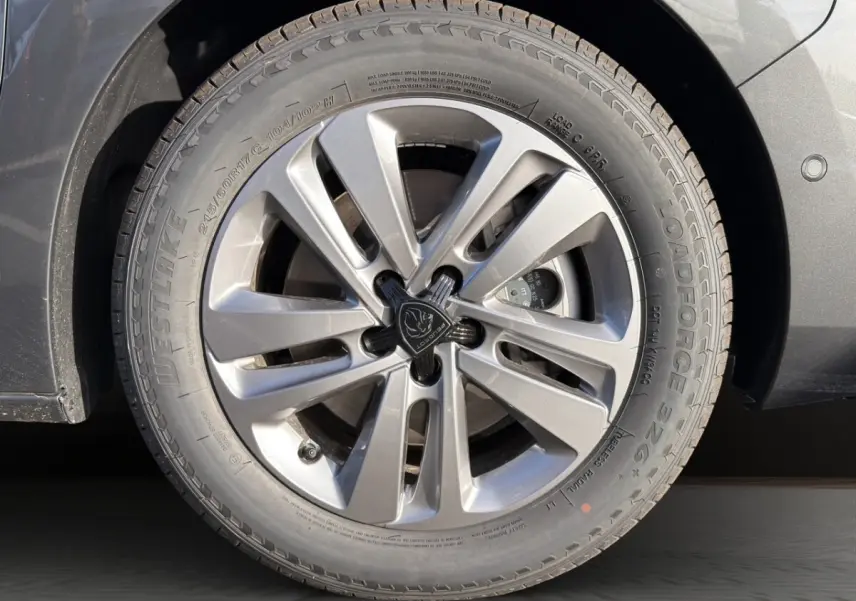 Gros plan sur la roue avant droite gris foncé du Peugeot Expert Fourgon avec jante alliage et logo central Peugeot.
