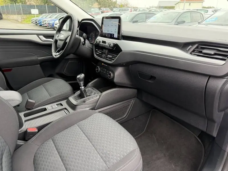 Vue intérieure côté conducteur du Ford Kuga 2024, finition Titanium, avec tableau de bord noir et écran tactile central.