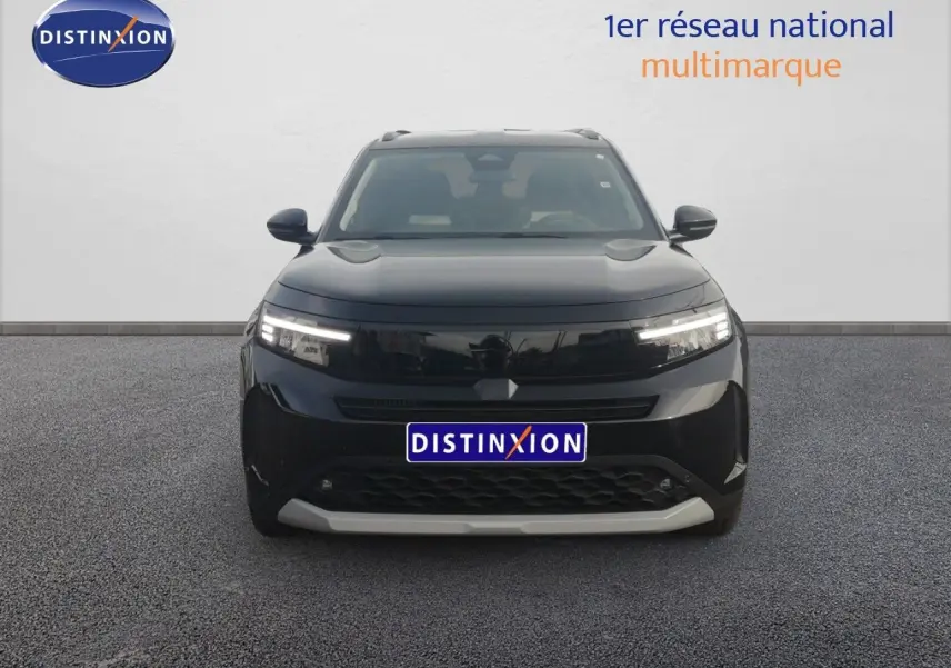 Opel Frontera 2025 noir Karbon, vue frontale avec phares LED allumés sur fond neutre.