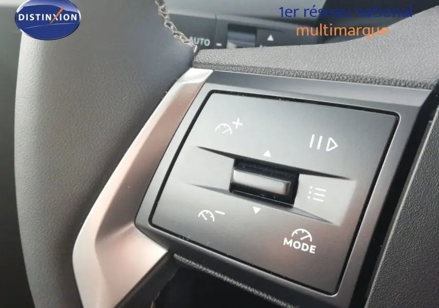 Gros plan sur les commandes au volant noir de l'Opel Frontera 2025, mettant en valeur les fonctions de régulateur et mode.
