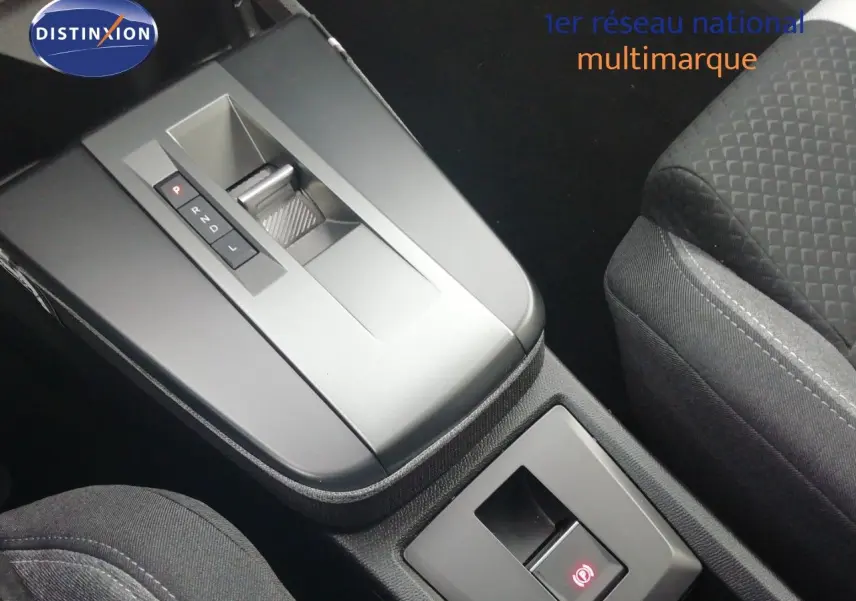 Vue rapprochée de la console centrale avec la boîte automatique et les sièges en tissu gris de l’Opel Frontera noir Karbon 2025.