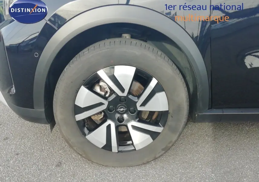 Gros plan sur la roue avant gauche noire Karbon de l'Opel Frontera 2025 avec jante alliage bicolore.
