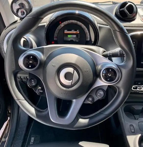 Vue rapprochée du volant et du tableau de bord gris de la Smart Fortwo Electrique Brabus Style 2019 avec commandes intégrées.