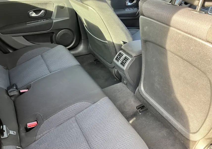 Vue arrière intérieure de la Renault Laguna 1.5l dCi 110 ch 2008, sièges tissu noir et aérateurs centraux au sol.