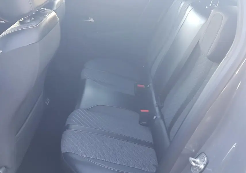Vue intérieure des sièges arrière gris du Peugeot 208 Hybrid 100 e-DCS6 Allure 2024, avec ceinture et appuie-tête visibles.
