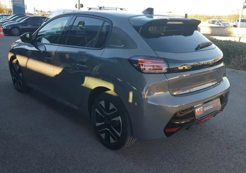 Peugeot 208 gris vue 3/4 arrière droit, jantes alliage 16 pouces et feux arrière LED distinctifs.