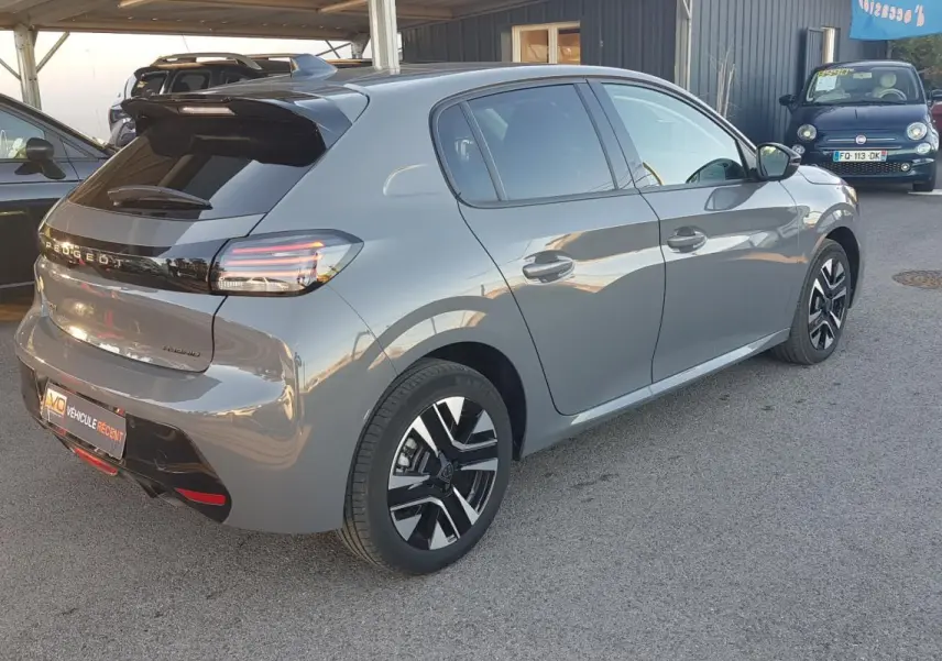 Vue 3/4 arrière droite d'une Peugeot 208 Hybrid gris métallisé avec jantes alliage et feux arrière LED.