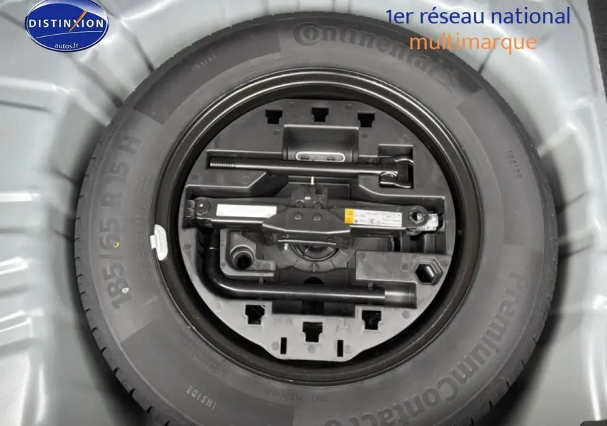 Roue de secours avec outillage intégré dans le coffre d'une Renault Clio V gris schiste, vue de dessus.