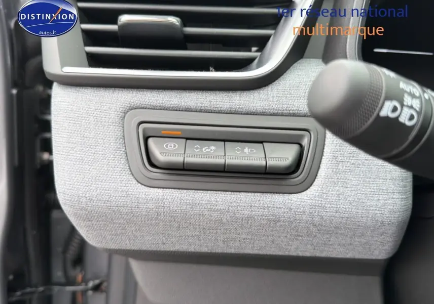 Détail des commandes d’éclairage et verrouillage sur tableau de bord gris clair d’une Renault Clio V 2026.