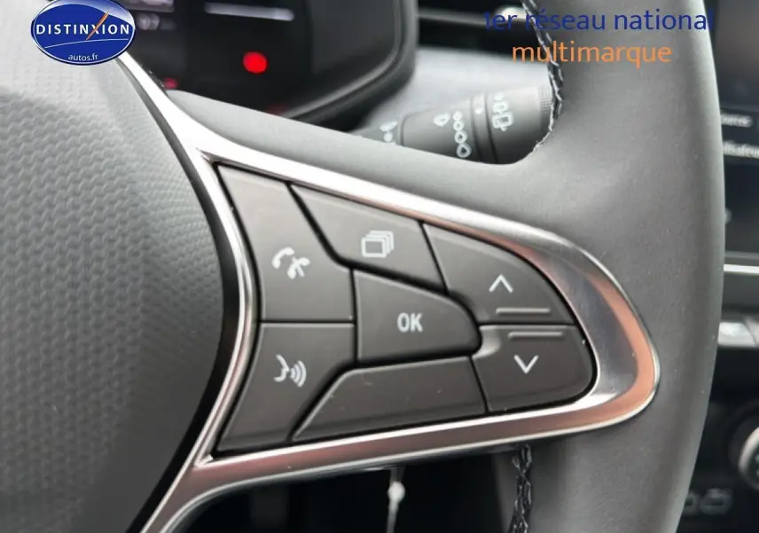 Gros plan sur les commandes multifonctions à droite du volant de la Renault Clio V gris schiste, avec boutons de gestion d'appels et menu.