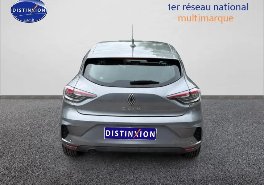 Vue arrière d'une Renault Clio V gris schiste avec feux LED et becquet arrière visible sur sol goudronné.