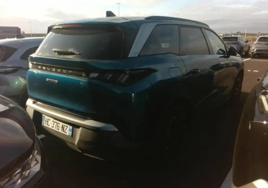 Vue 3/4 arrière droite d’un Peugeot 5008 bleu foncé avec toit clair et feux arrière à LED en forme de griffes.