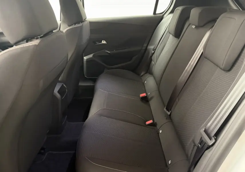 Vue intérieure côté droit des sièges arrière noirs de la Peugeot 308 2024, banquette 3 places avec ceintures visibles.
